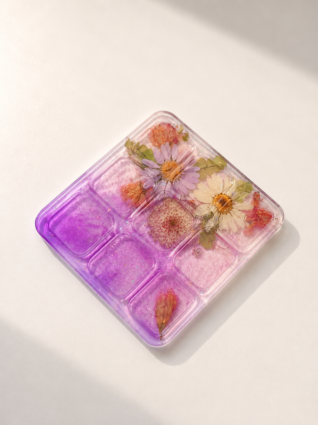 Base quadrata del tris artigianale in resina rosa e viola con fiori essiccati e glitter iridescenti