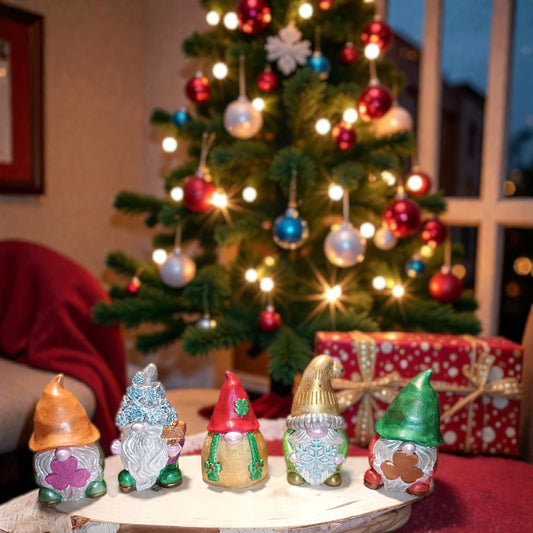 Gnomi natalizi artigianali in gesso con colori metallizzati davanti albero di natale