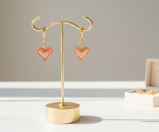 Orecchini Cuori Rosè esposti su supporto per gioielli – ciondolo a cuore in resina rosa handmade