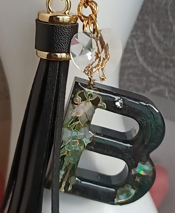 Primo piano ciondolo portachiavi  lettera B personalizzata in resina con charm e nappina pelle sintetica, pezzo unico