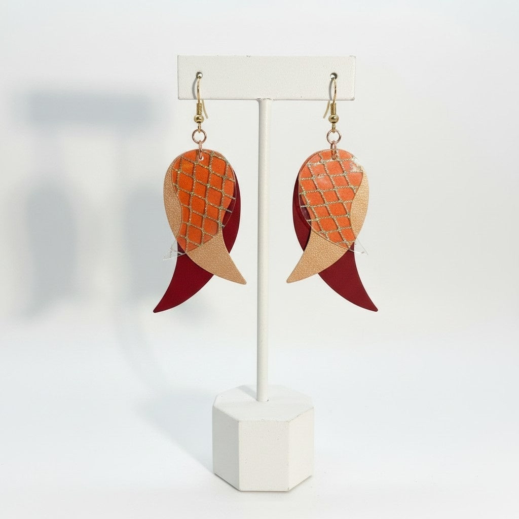 Orecchini pendenti a forma di foglia in similpelle color rosso borgogna, beige con dettaglio olografico, su espositore bianco, fatti a mano